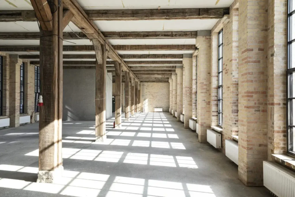 Plasterboard ceiling between exposed beams in a showroom at Kuglegården on Holmen in Copenhagen before the acoustic ceiling
